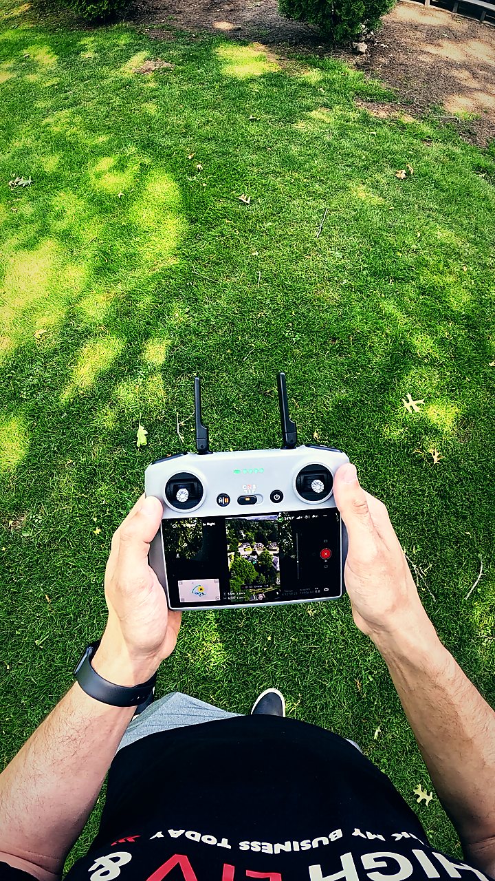 Flying a drone over a client property, with the live aerial view on the controller