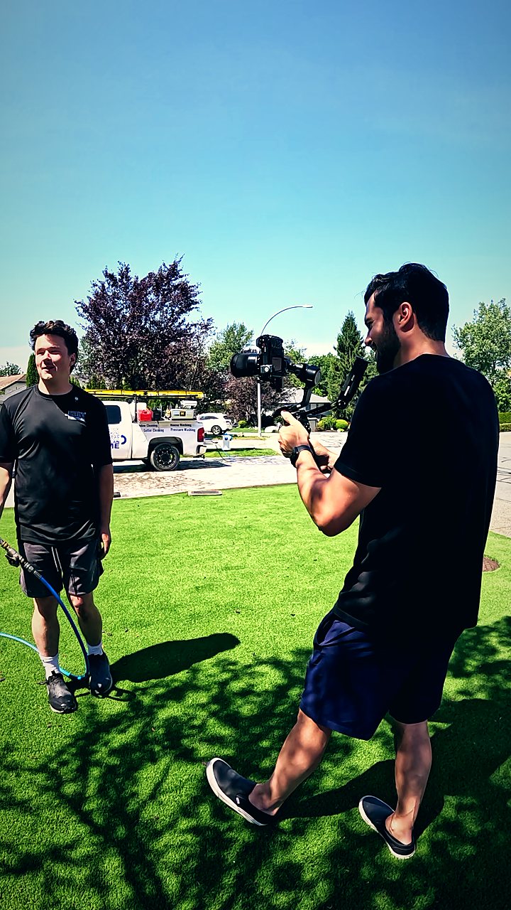 Murilo filming an exterior house washing crew on a front lawn